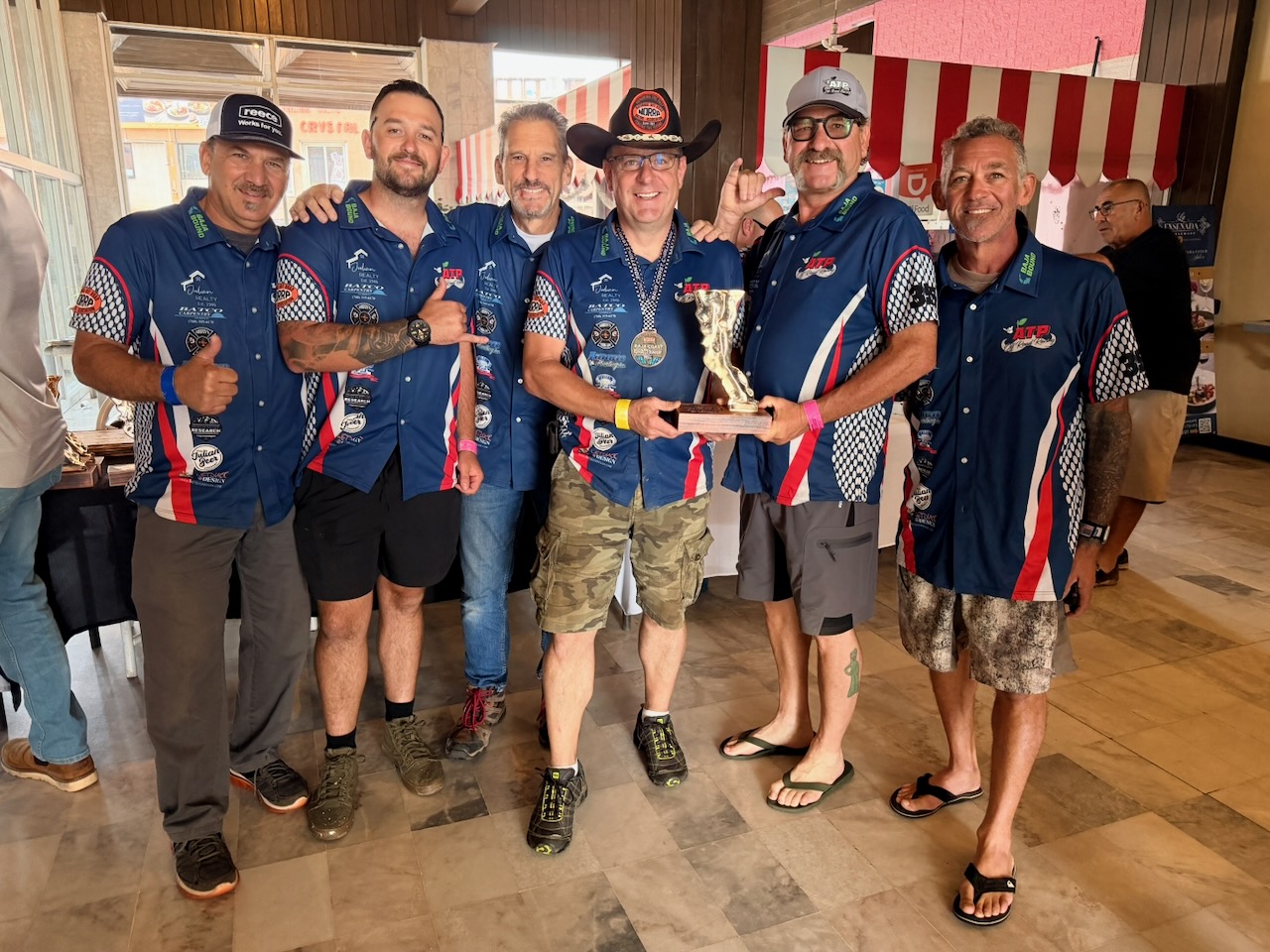 High Altitude Racing and Apple Town Posse team members celebrating with the 2026 NORRA 500 third-place trophy