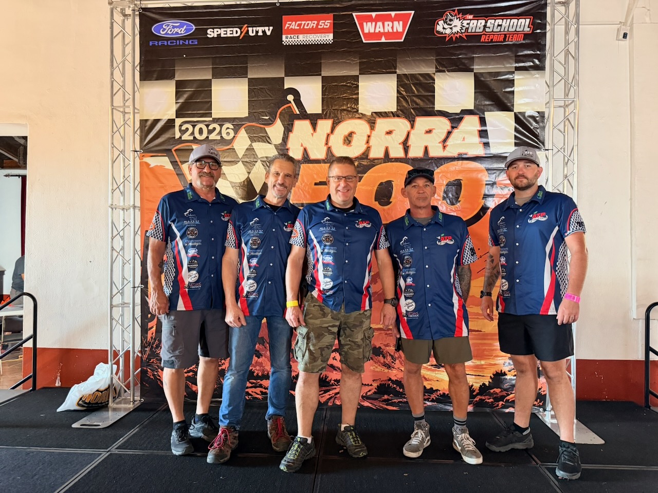Team members posing at the NORRA 500 registration sign