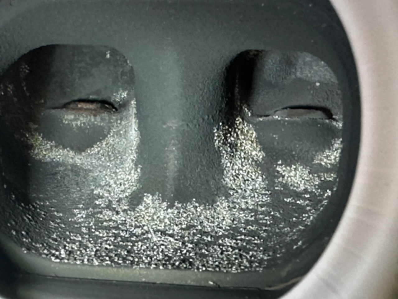 Close-up of glassy residue formed from melted desert dust inside the exhaust port