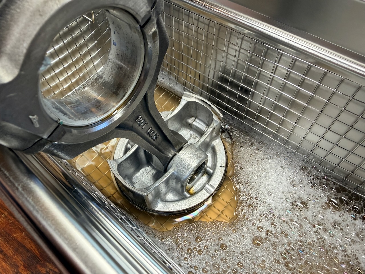 Piston being cleaned in an ultrasonic cleaner